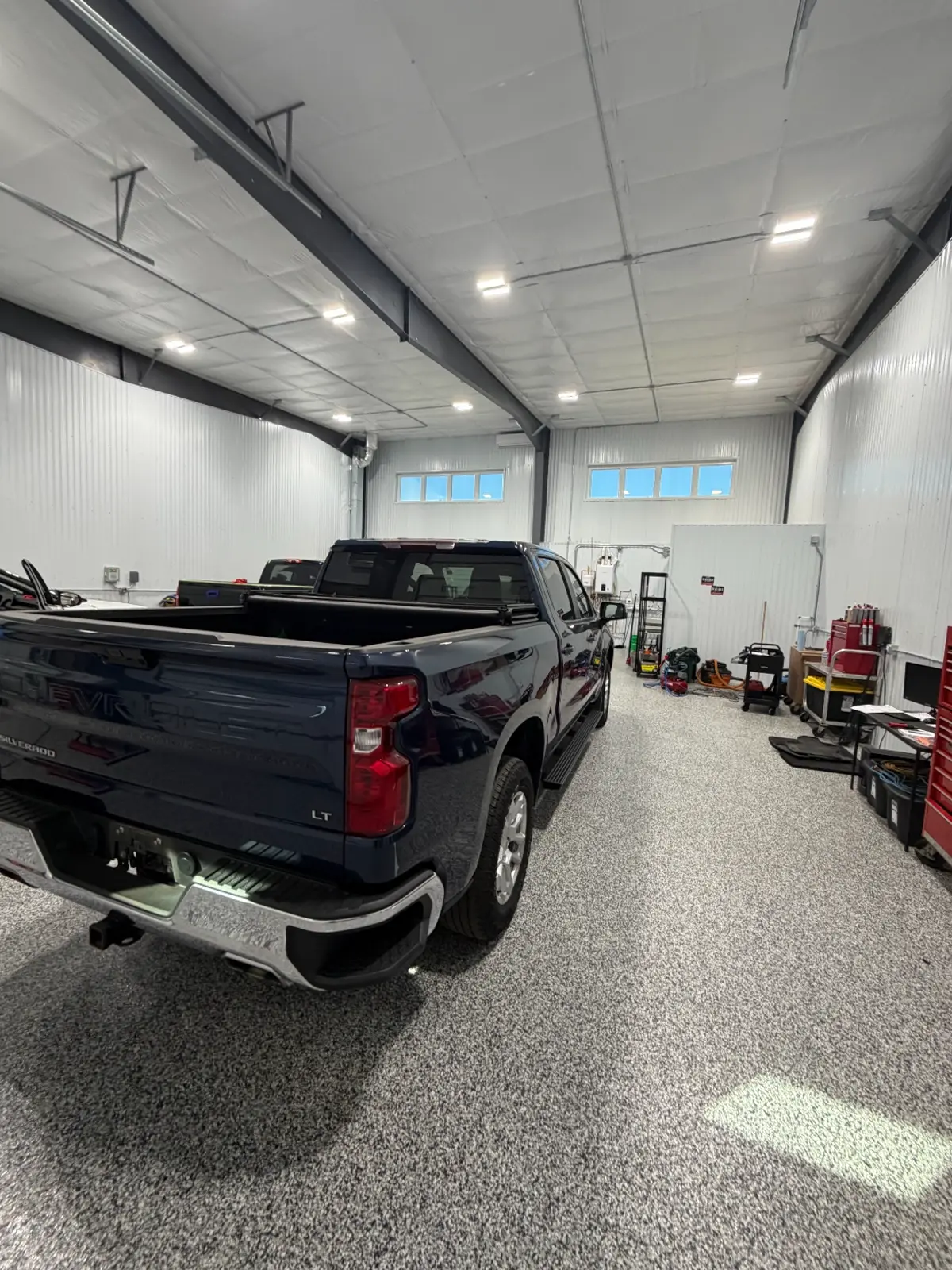 Hail damage inspection under controlled lighting in the River Falls shop